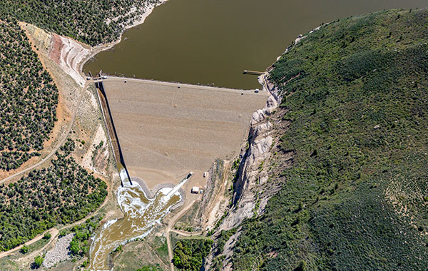 Bird's eye view of a reservoir, dam, and river below