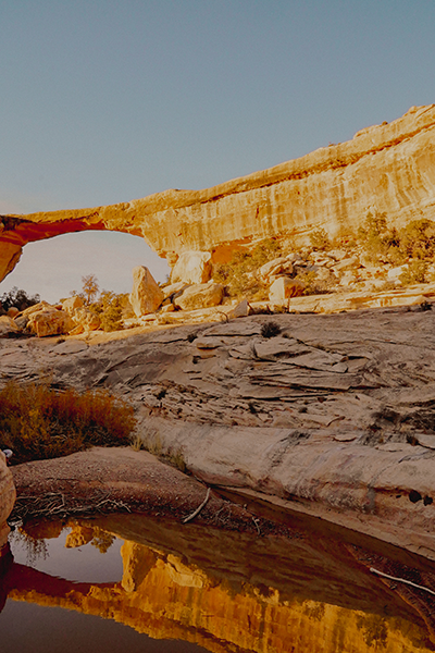 Desert sandstone arch with water in front. 